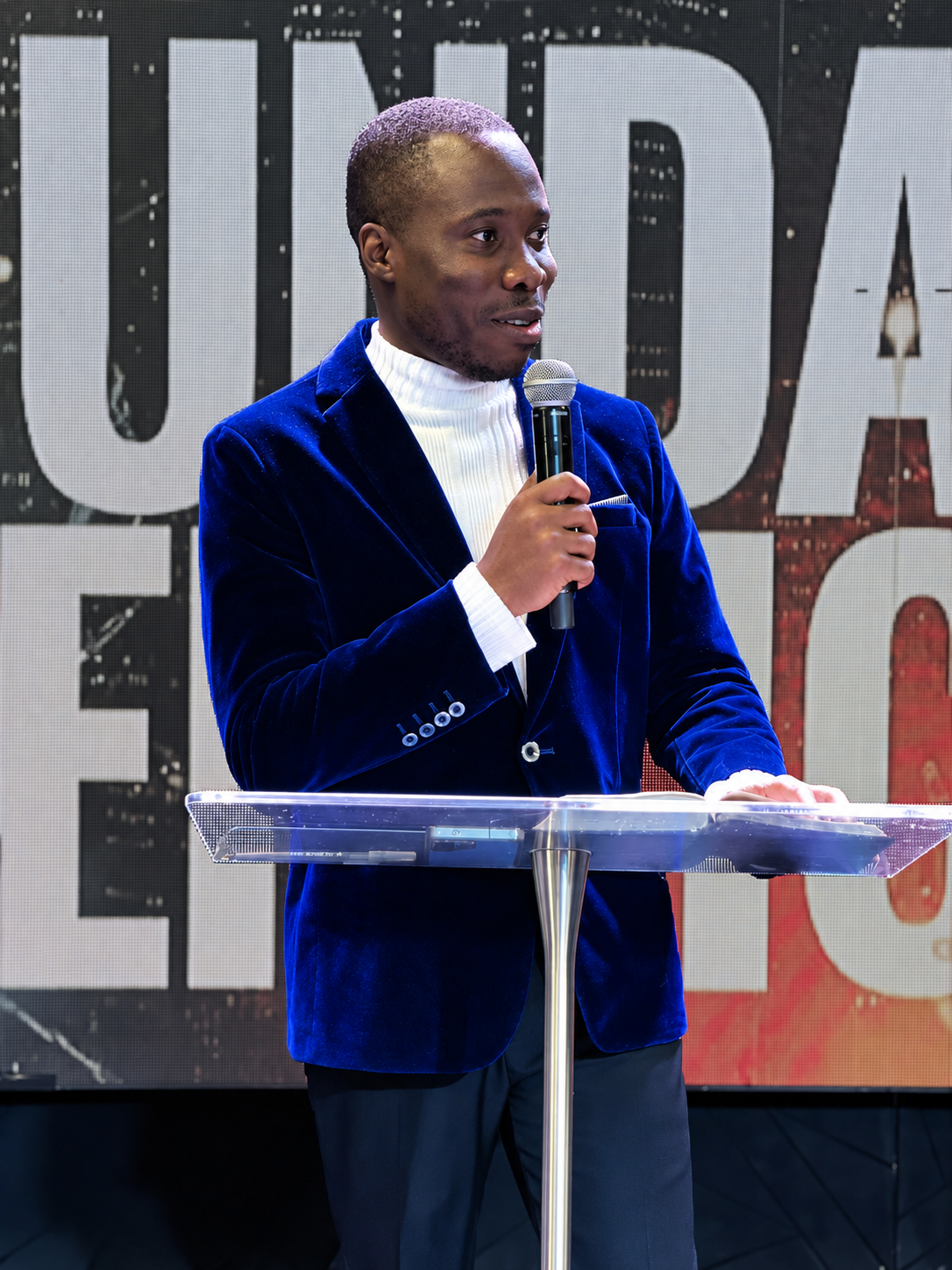 Pastor Maro speaking at a lectern